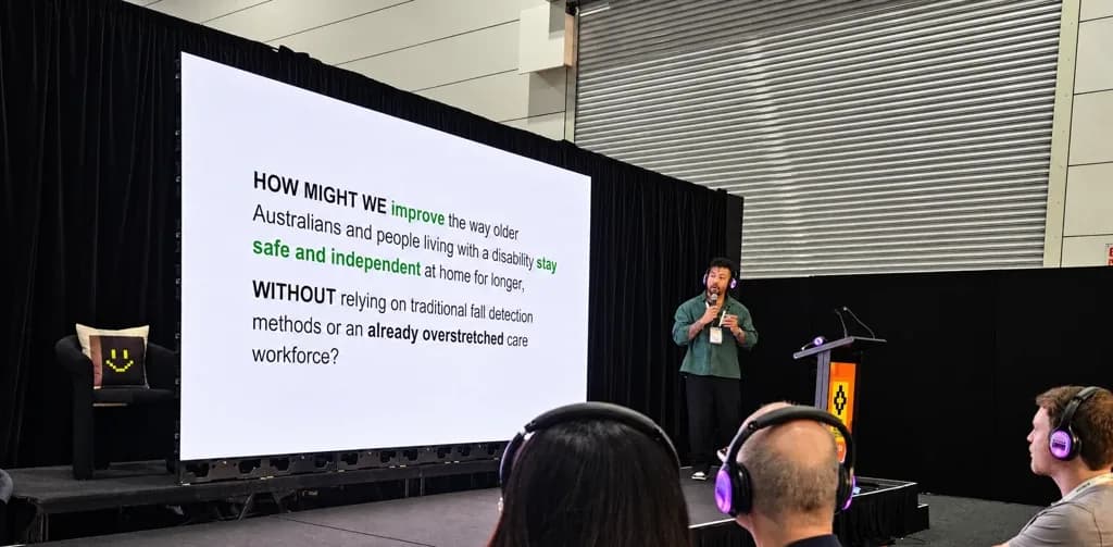 Daniel Barreto on stage presenting the Vitara CarePilot "How might we" slide at the Digital Health Festival Startup Showdown in Melbourne